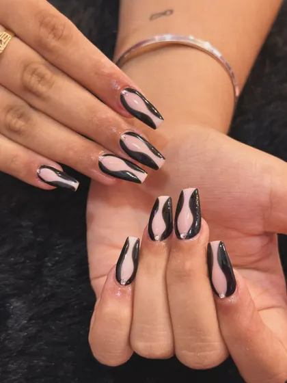 Abstract art you can wear. This design features bold, black fluid shapes over a neutral base on coffin-shaped nails. It’s a modern, graphic look that is both sophisticated and edgy.