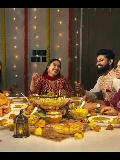 A festive dinner scene from the ad film, where all the cast members have coordinated, natural makeup that looks authentic and celebratory.
