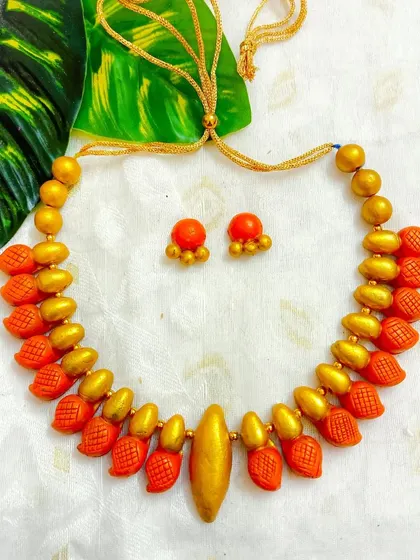 The sleek choker in a vibrant orange and gold.
