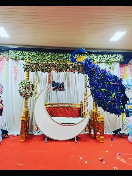 The peacock-themed decor in natural light, showing the contrast between the pink curtain backdrop and the blue floral peacock.