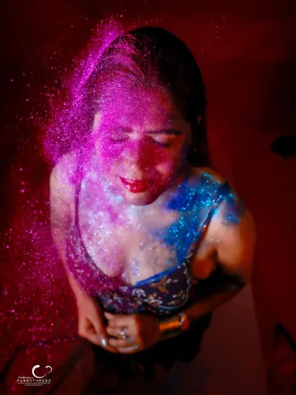 A high-angle shot of glitter raining down. This portrait is expressive and full of a joyful, celebratory energy.