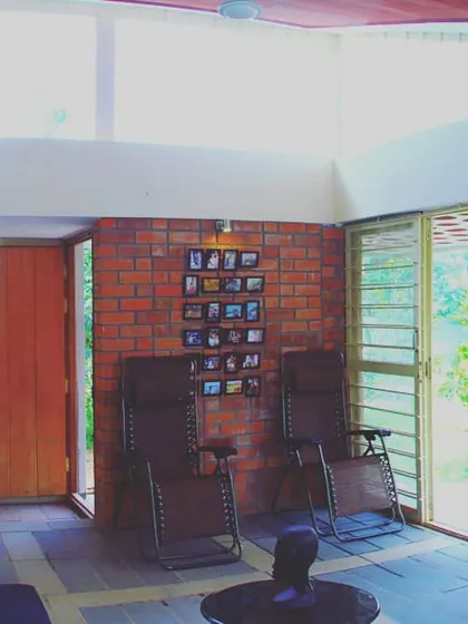 I believe in using locally available materials to create authentic spaces. This living area features exposed wire-cut brick walls and large windows, flooding the room with natural light and creating a rustic yet contemporary home environment that feels connected to its surroundings.