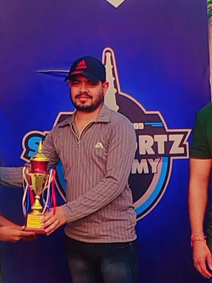 A young cricket champion receives his trophy.