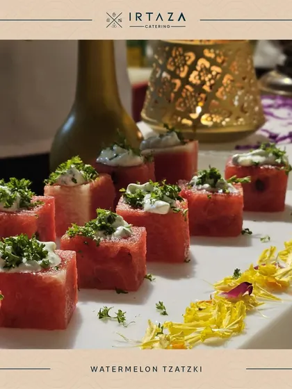 A refreshing and healthy appetizer of Watermelon Tzatziki. Cubes of fresh watermelon are topped with a creamy yogurt-based sauce and herbs, perfect for a summer event.