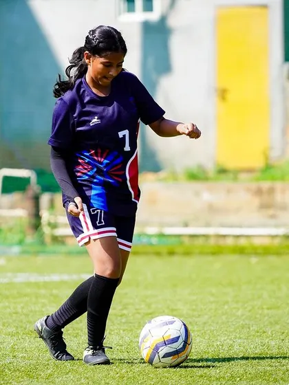 A player calmly controls the ball, looking up to assess her options before making the next move in the game.