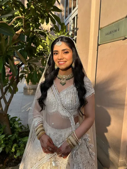 Hollywood waves with a high half-ponytail for a glamorous Sangeet look. This hairstyle is all about volume and drama, perfect for making a statement.