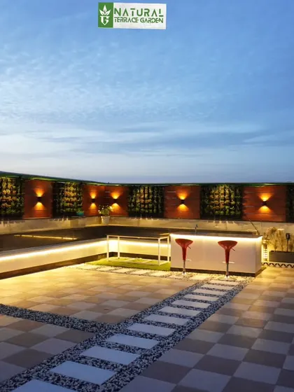 The long, illuminated bench seating and bar area along the vertical garden wall in our Palam Vihar project.