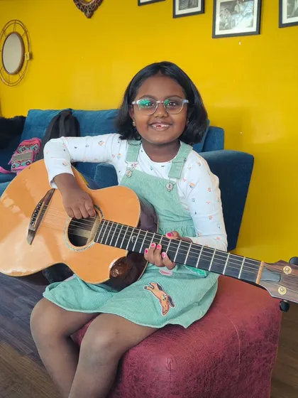 The happy smile of a young guitarist at our summer camp. It's all about fun, friends, and music.