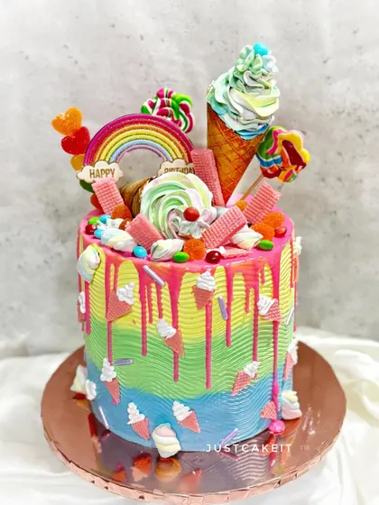 A candy lover's dream cake. This colorful creation is loaded with lollipops, ice cream cones, and various candies, with a piñata surprise inside.