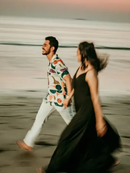 A candid, motion-blur shot of a couple walking along the beach. This artistic technique adds a dynamic and dreamy quality to the pre-wedding photograph.
