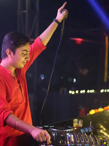 On the mic during a Diwali event, with my hand raised to hype the crowd. I'm always ready to guide the energy of the room.
