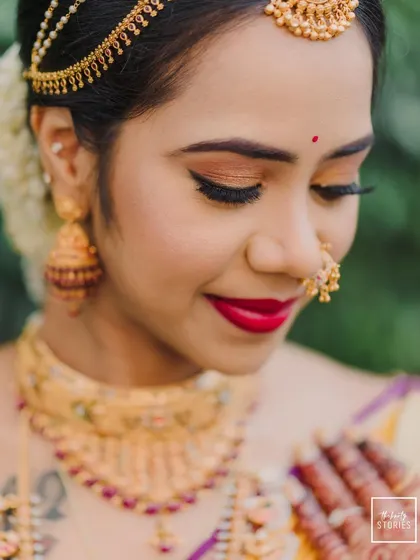 An intimate close-up of the bride's face, showcasing her beautiful makeup, gold jewelry, and serene expression.