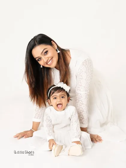 Two peas in a pod! This mother and daughter duo, in their matching white lace dresses, share a moment of pure joy and connection.