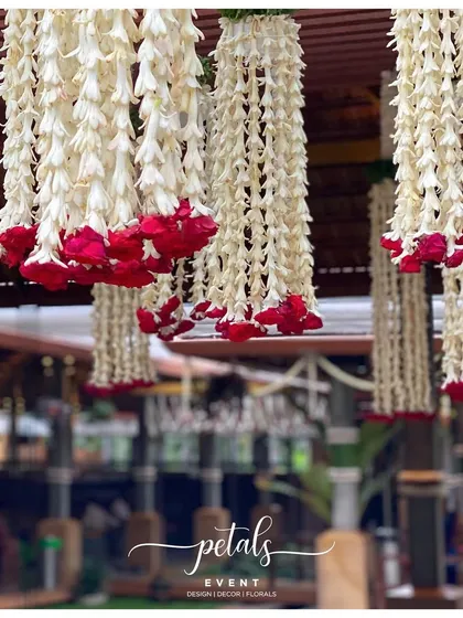 Hanging garlands of white tuberose and red roses, a classic and elegant combination for traditional wedding decor.