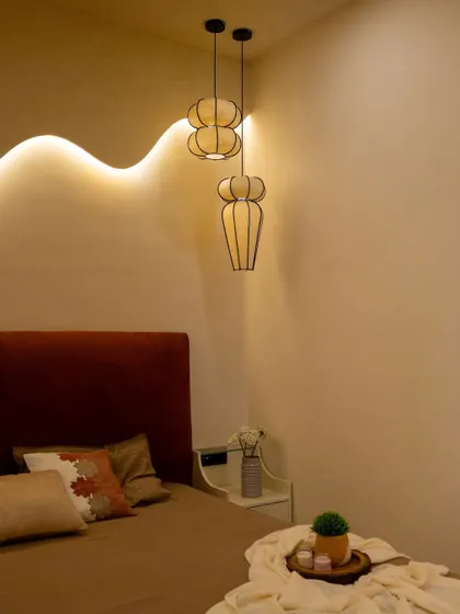 A closer look at the elevated platform bed and the sculptural pendant lights that add a touch of elegance to this minimalist bedroom.