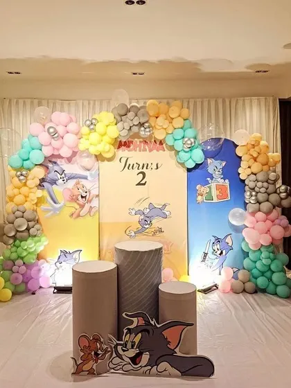 A nostalgic Tom and Jerry theme for a 2nd birthday. This setup includes custom printed backdrops with the characters, surrounded by pastel-colored balloon arrangements and character cutouts.