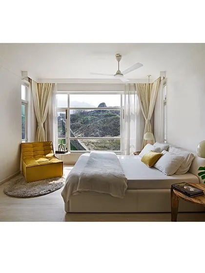 I believe in the power of simplicity to create calm. This minimalist bedroom is designed as a serene sanctuary, using a clean white palette and large windows that frame the natural landscape, proving that sustainable design can be both modern and tranquil.