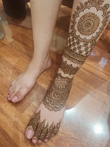 A side view of the full-leg mehendi, showing how the patterns wrap all the way around the leg.