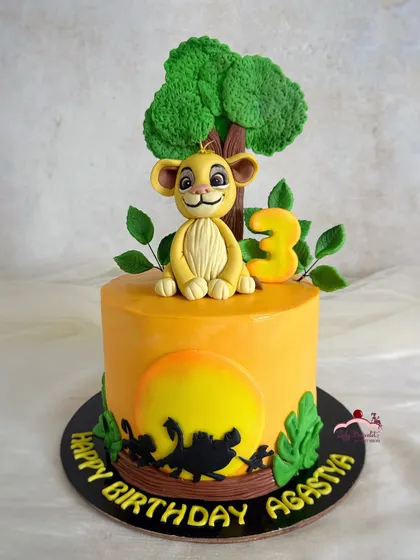 Roaring into another year with Simba! This Lion King cake features a sunset silhouette and a handcrafted Simba topper sitting under a tree.