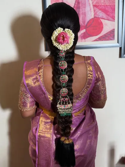 For this baby shower look, I created a traditional braid adorned with heavy temple jewellery, including jhumka-style hangings. The fresh flowers at the top add a touch of softness.