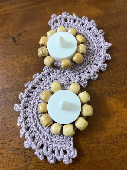 My crochet tealight runner with two holders, shown before being lit. The natural wooden beads and soft lavender yarn create a rustic yet elegant look.
