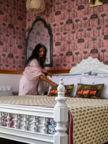 A close-up of the heirloom bed in the guest room, dressed with hand-embroidered cushions and a bedcover from the owner's wedding trunk.