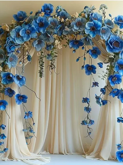 A breathtaking floral arch made of cascading blue flowers over a sheer curtain, perfect for a wedding ceremony or an elegant photo booth.