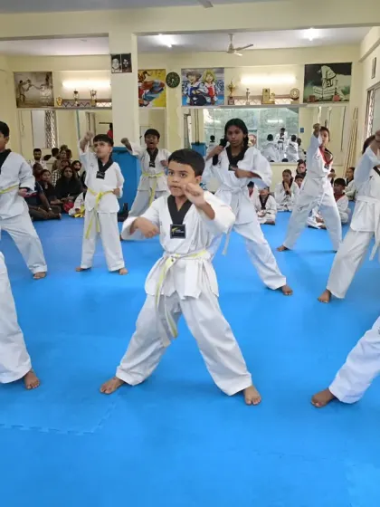 A class of white and yellow belts practicing their punches and kicks.