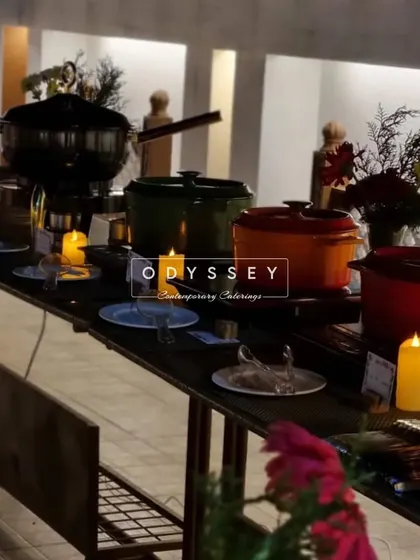 An evening buffet setup with rustic-chic decor, including candles and cast-iron pots. We tailor the ambiance of our food stations to match the overall theme of your event.