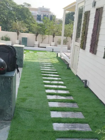 A closer look at the stone pathway design on a terrace. I carefully cut and fit the artificial grass around each slab to create a clean, integrated look that is both practical and beautiful.