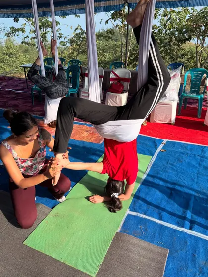 Guiding a student through her first inversion. These moments of breakthrough and trust are what make teaching so fulfilling.