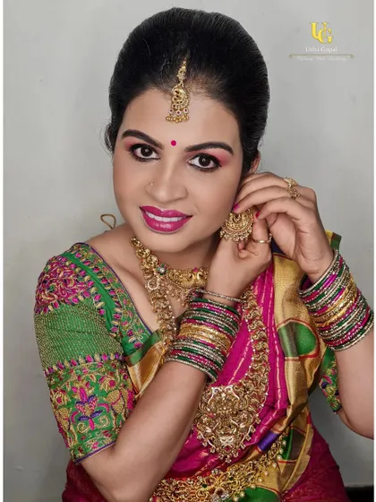 Preethi looking gorgeous and ready for the ceremony. This candid shot captures her adjusting her jewelry, showing the complete look with her colorful saree and intricate gold necklaces.