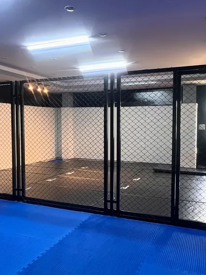 Different views of our MMA cage and the surrounding dojo. We've invested in top-tier infrastructure to give our fighters a competitive edge.