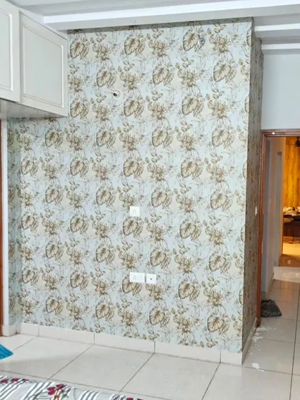 A bedroom wall with a delicate floral pattern, adding a touch of charm and elegance to the space.