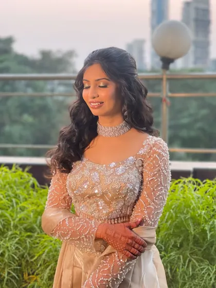 The perfect smile to complete the look. Her radiant makeup and beautifully styled hair with a sparkly bow make her shine, ready for a night of celebration.