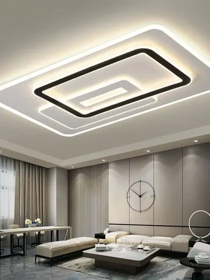 This modern living space features a striking geometric ceiling light. The neutral grey walls and minimalist furniture create a sleek and contemporary office or lounge area.