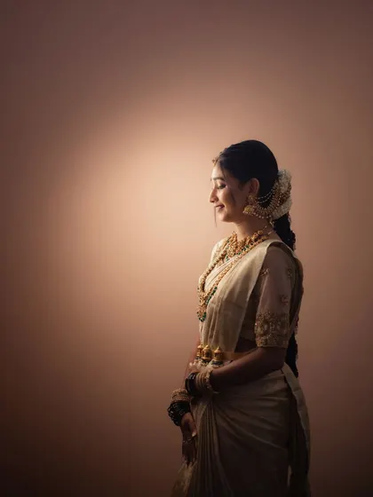 A simple, elegant portrait of a bride against a warm, softly lit background. Her serene, smiling profile is the focus of this beautiful, minimalist shot.