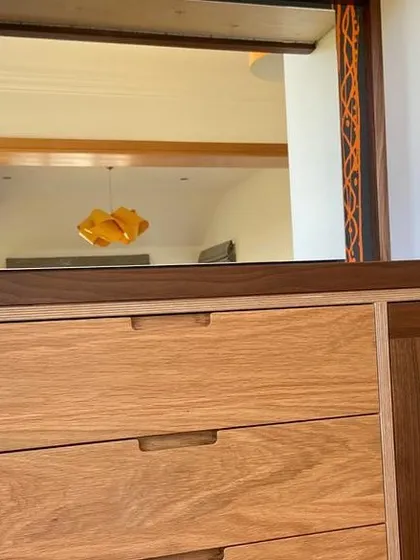 This detail shot highlights the contrast between the solid oak drawer fronts and the rich grain of the solid walnut worktop and frame. The integrated finger pulls provide a clean, handleless look.