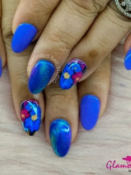 Make a statement with this electric blue set. We paired solid blue nails with accent nails featuring a galaxy of hand-painted flowers in pink, yellow, and blue, creating a vibrant and artistic look.