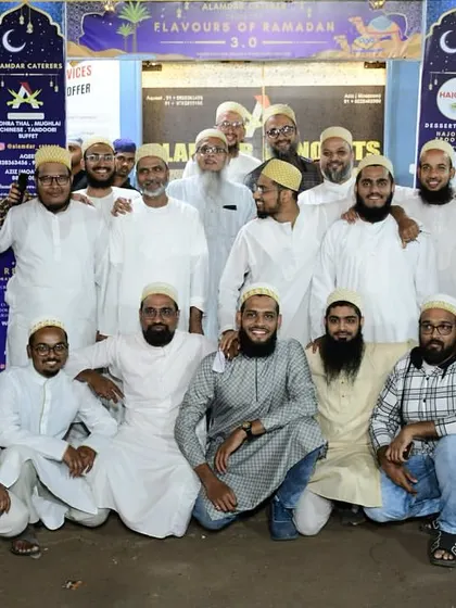 A large group of men from the Bohra community posing for a photo. We are proud to serve you.