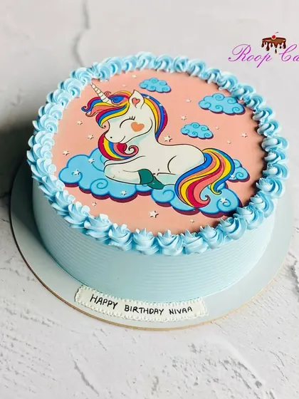 A sweet and simple unicorn cake. This half-kg design features an edible print of a cute unicorn sleeping on a cloud, surrounded by a piped blue border.