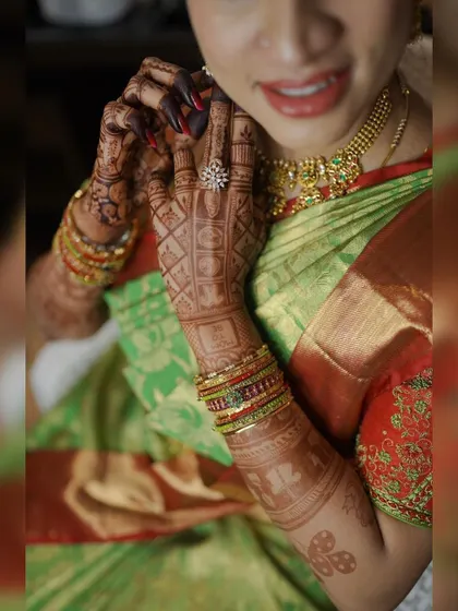 A candid shot of a mom-to-be getting ready for her baby shower. The intricate grid pattern and traditional motifs on her hands add to her festive look.