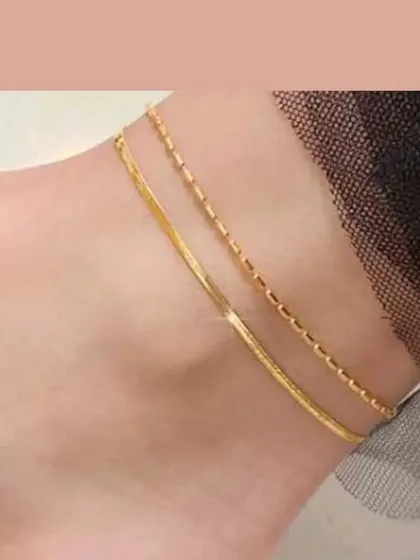 A layered anklet combining a flat snake chain and a delicate box chain. This piece offers a stylish, pre-stacked look.