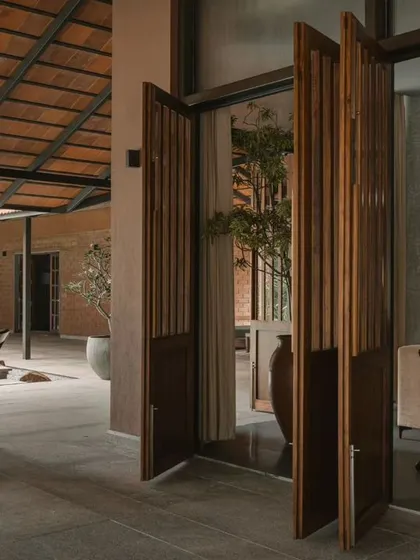 These pivoting slatted doors connect the interior living room to the poolside patio. They can be opened to merge the two spaces for entertaining or closed to create a more intimate indoor setting.