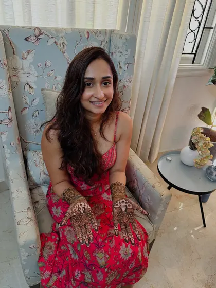 The bride proudly presents her detailed portrait and peacock mehndi.