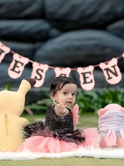 A sweet first birthday setup in our garden, with a personalized banner and some of the birthday girl's favorite toys.