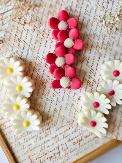 The Floral Symphony candles laid out, showing the variety in color and design. These are hand-poured and make for adorable additions to gift hampers or as standalone decor pieces.