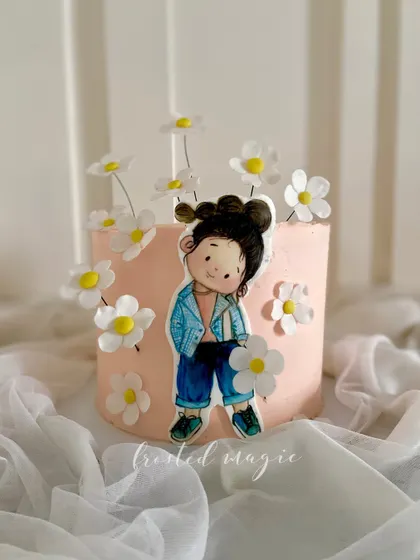 This cake features a hand-painted character using cocoa butter, surrounded by delicate wafer paper daisies. It's a beautiful example of how I combine different edible mediums to create a unique artistic style.