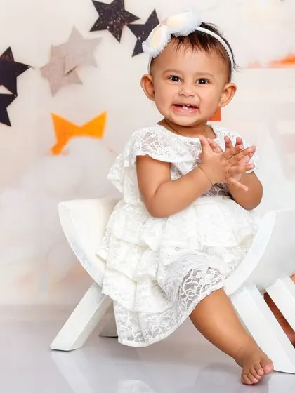Clapping her hands with glee, this little one is the star of the show in our whimsical "Moon and Stars" setup.