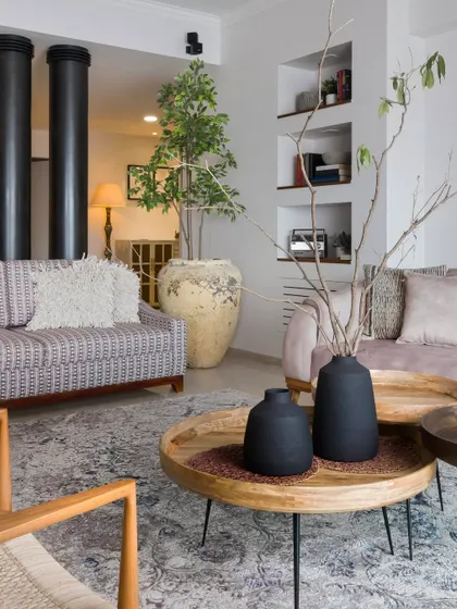 This living room shows how thoughtful design can bring intimacy to open spaces. We introduced a hallway illusion with two full-height pillars, and the palette of soft pinks and patterned upholstery adds warmth and playfulness.